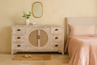 Lifestyle image of a white mango wood and rattan sideboard with six drawers and two compartments—handcrafted bedroom furniture blending Indian artistry with Scandinavian design.