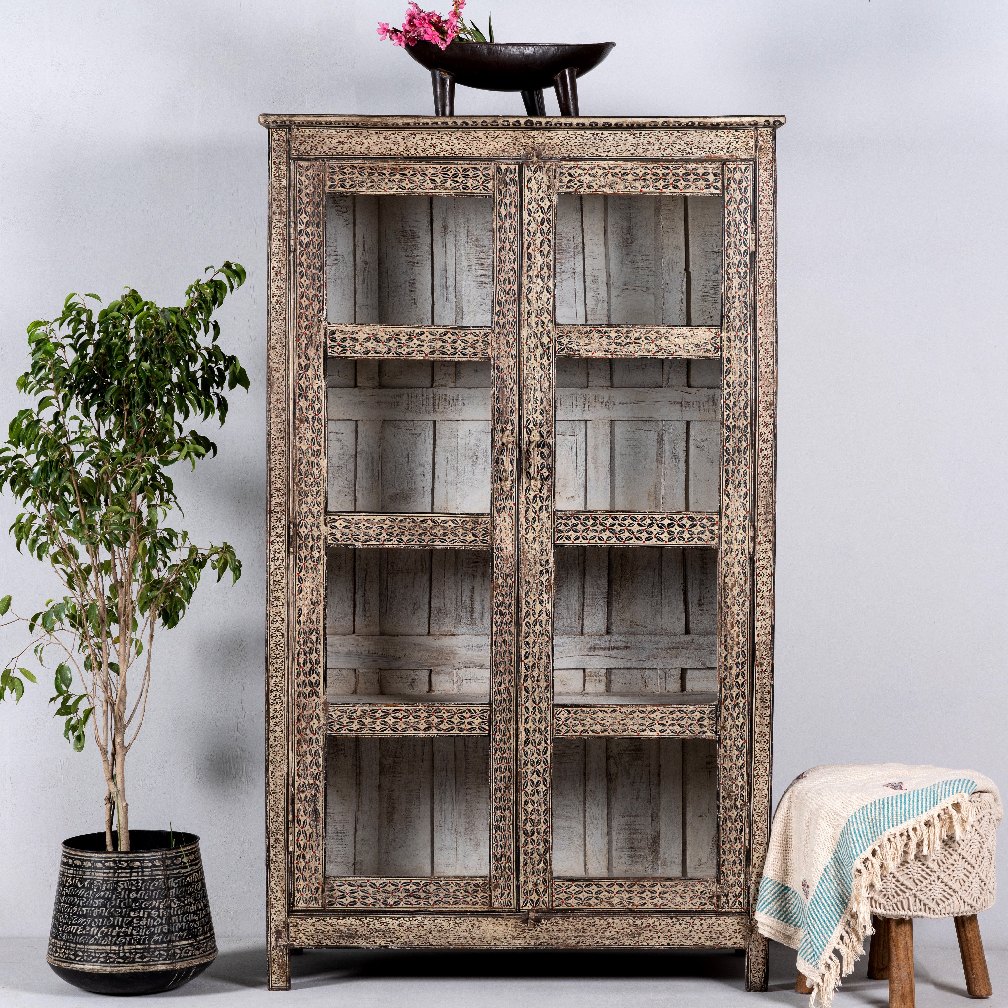 Handcrafted display cabinet made from reclaimed Teak wood with glass doors and Sanskrit motifs; sustainable and unique wooden furniture, 182 × 93 × 42 cm.