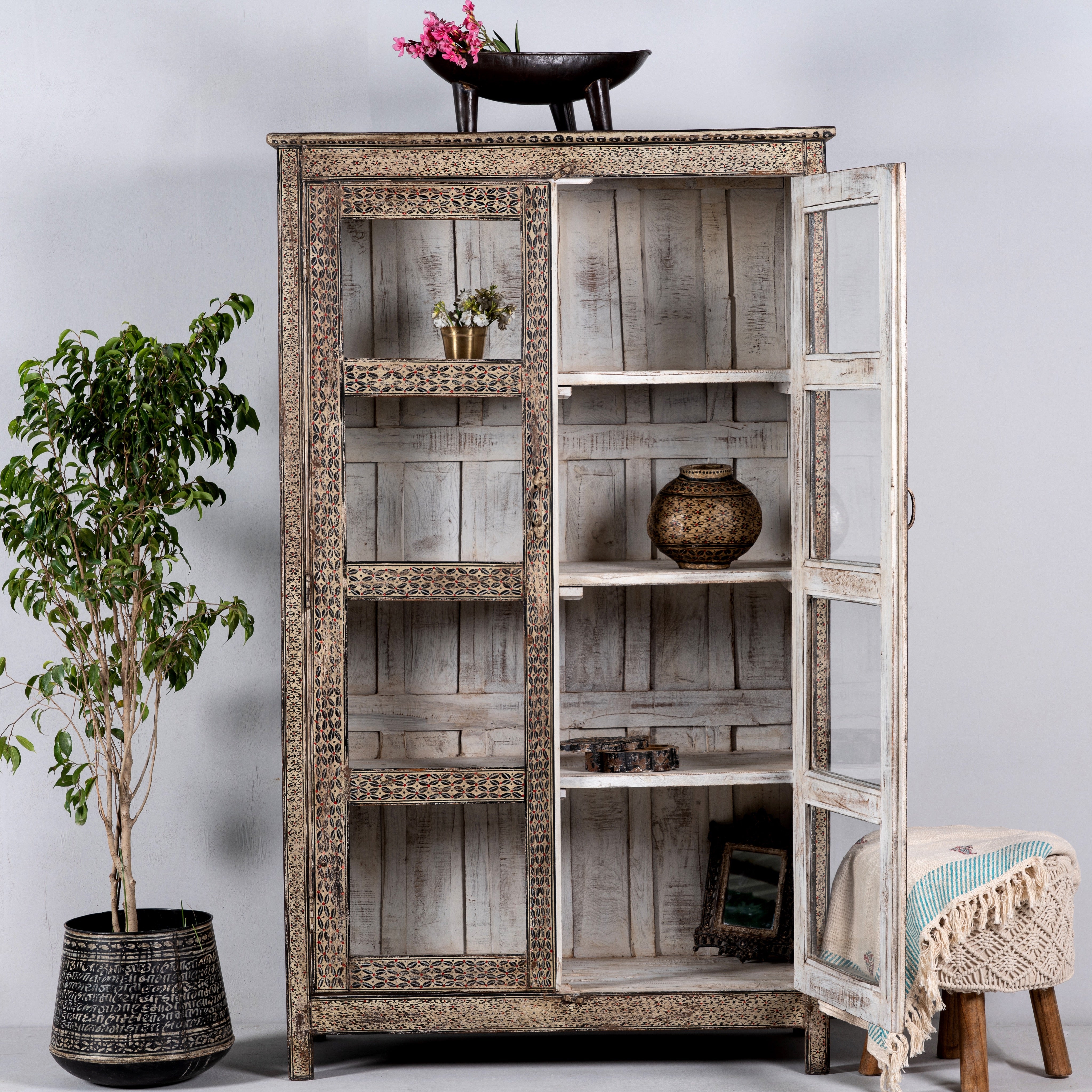 Open door image of a handcrafted display cabinet made from reclaimed Teak wood with glass doors and Sanskrit motifs; sustainable and unique wooden furniture, 182 × 93 × 42 cm.