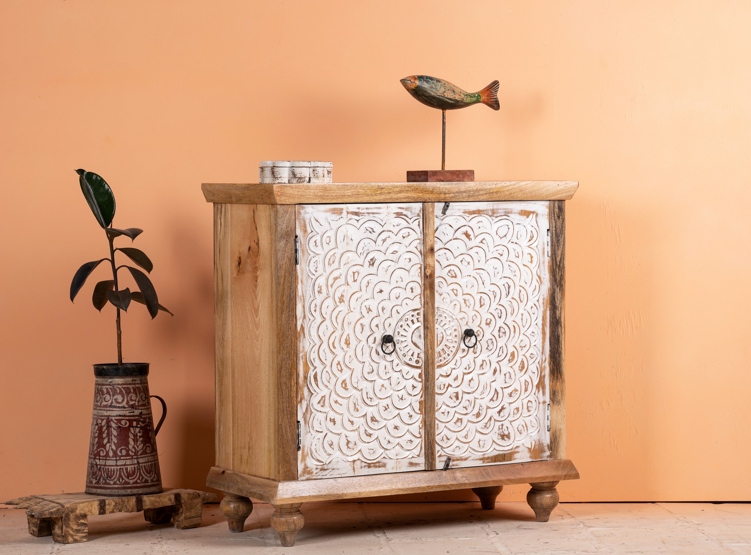 Side angle image of a carved wood furniture cupboard with white-washed engraved doors and mango wood body, 90 × 90 × 40 cm.