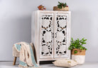 Side angle image of a white washed mango wood cabinet with three compartments and hand‑carved floral doors, vintage style, 75 × 40 × 120 cm.