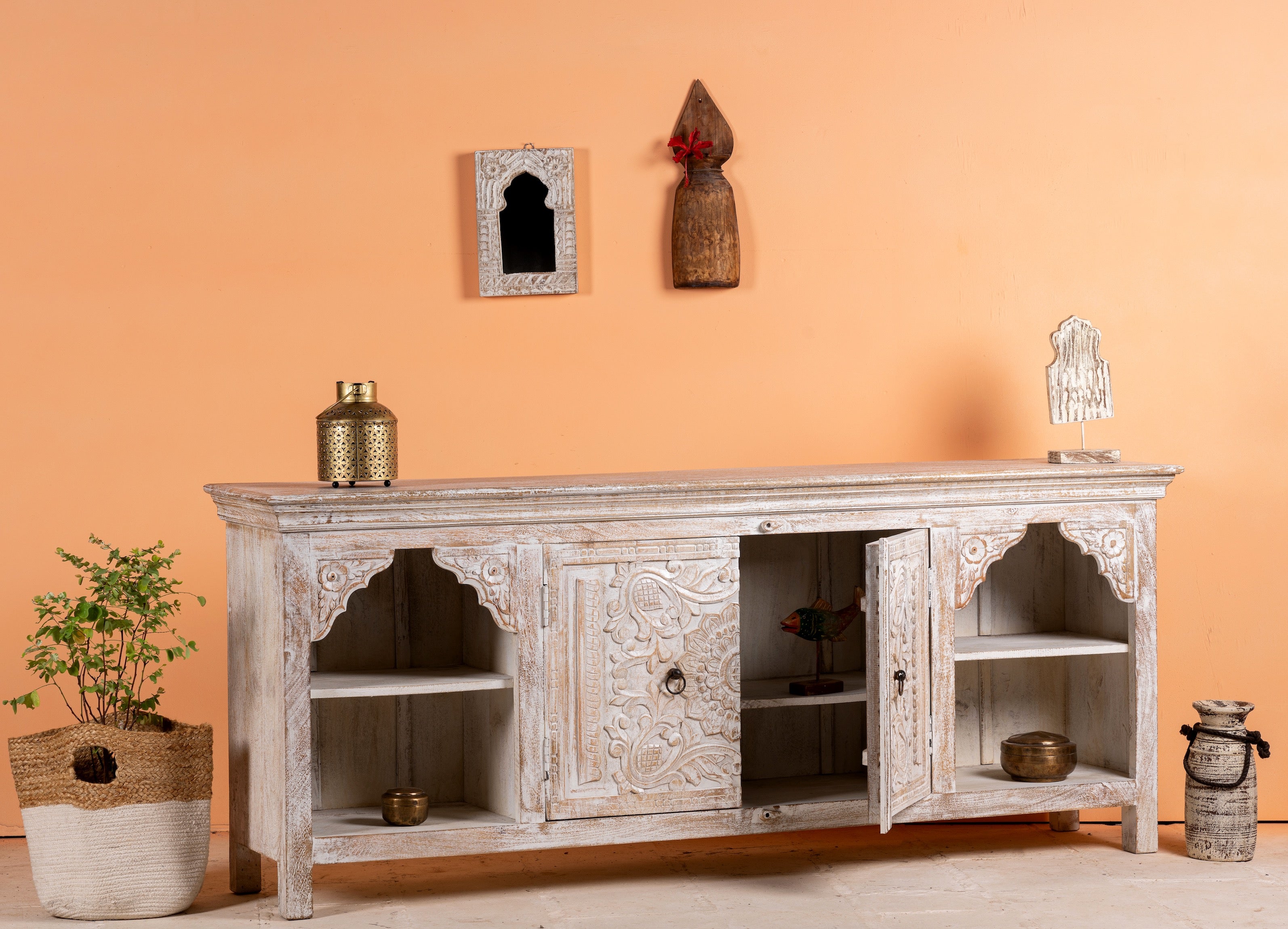 Side angle image with open door of a hand-carved mango wood Mediterranean lowboard with floral engravings and whitewashed finish – carved wooden furniture combining traditional Indian craftsmanship with rustic elegance.