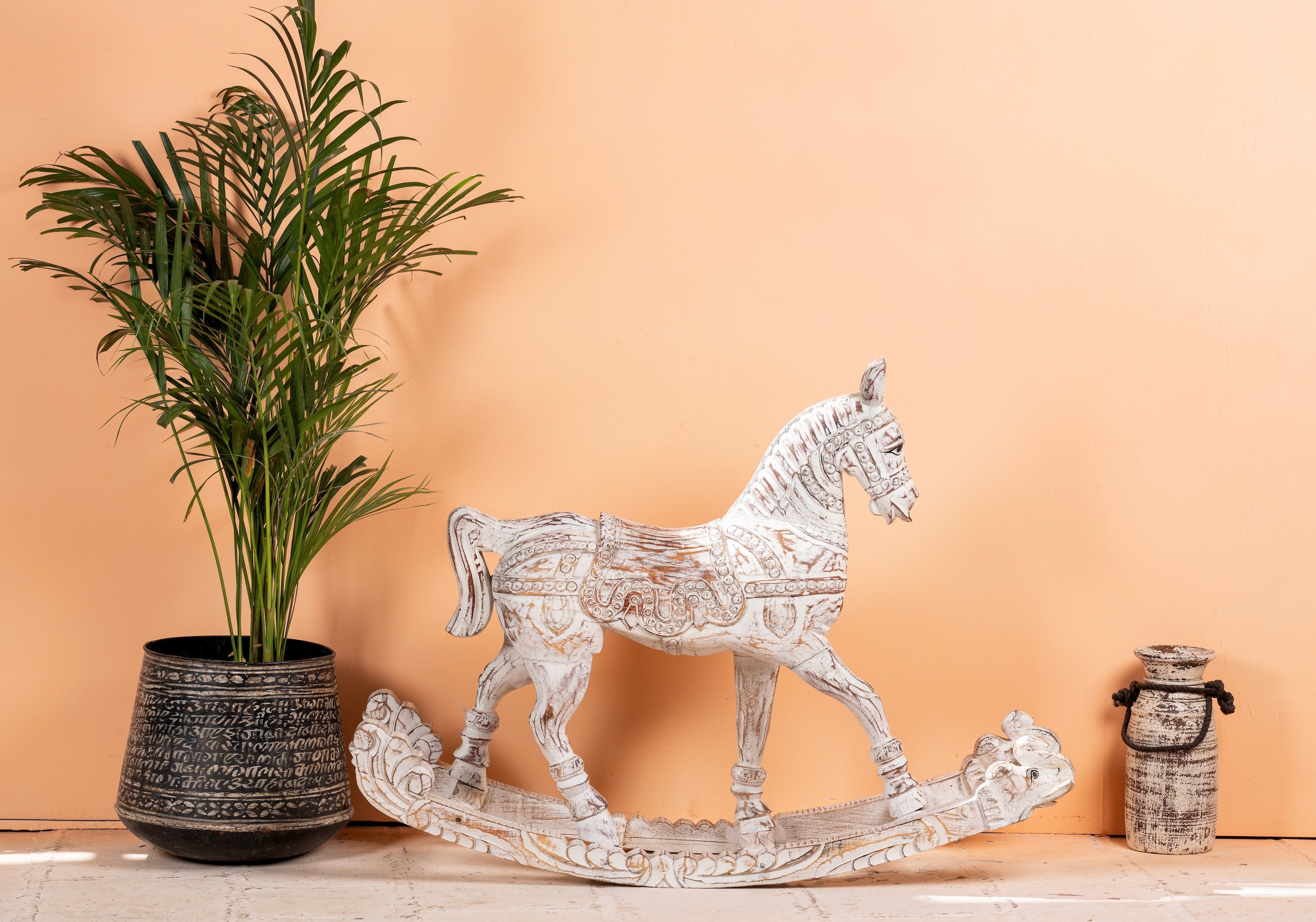 Side angle image of a hand-carved whitewashed mango wood rocking horse – artistic Indian home accessory and mango wood décor, ideal for entryways or living rooms, 105x80x30cm.