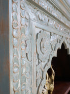 Close up image of a hand-carved mango wood bookcase with Mediterranean design and open shelving – mango wood shelving and hand carved wooden furniture with natural finish.