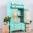Open door image of a vintage furniture cabinet in turquoise-washed mango wood with rattan door panels and hand-carved engravings, 80 × 148 × 40 cm.