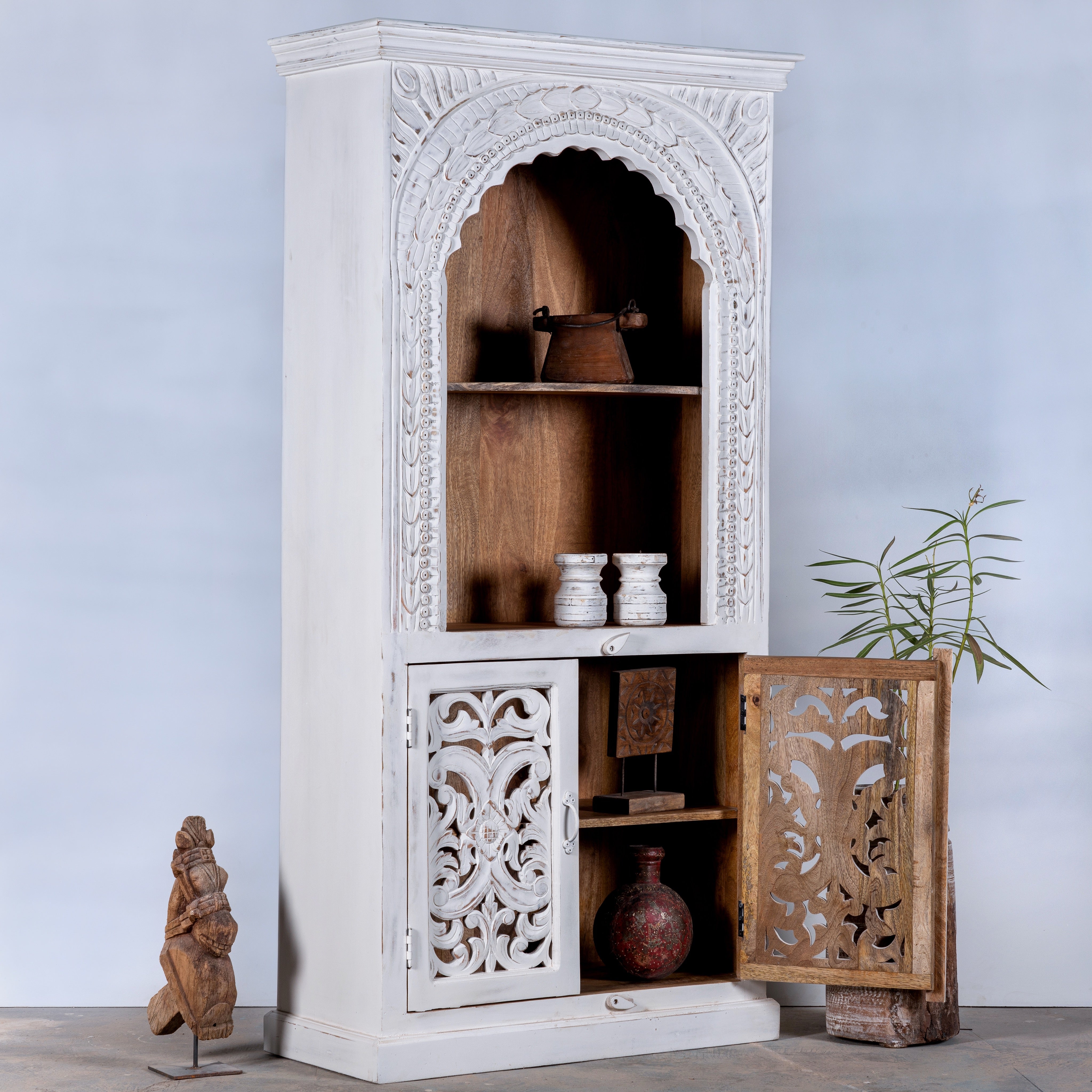 Open door image of a handcrafted mango wood shelving unit with Indian carvings and four compartments; ideal for Indian home decor, 180 × 90 × 40 cm.