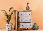 Side angle image with open drawers of a Mango wood carved chest of drawers with whitewashed floral engraved fronts, 80 × 40 × 90 cm.