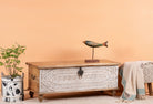 Side angle image of a hand-carved mango wood vintage chest with whitewashed finish and iron fittings – elegant storage for bohemian or rustic interiors.