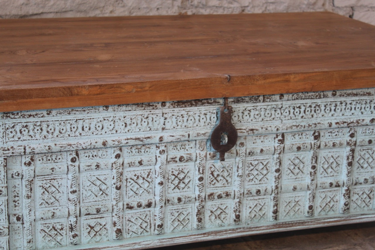 Close up image of a antique Indian chest coffee table in blue with brass fittings – solid teak iron fitted wooden chest repurposed as living room table with storage.