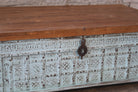 Close up image of a antique Indian chest coffee table in blue with brass fittings – solid teak iron fitted wooden chest repurposed as living room table with storage.