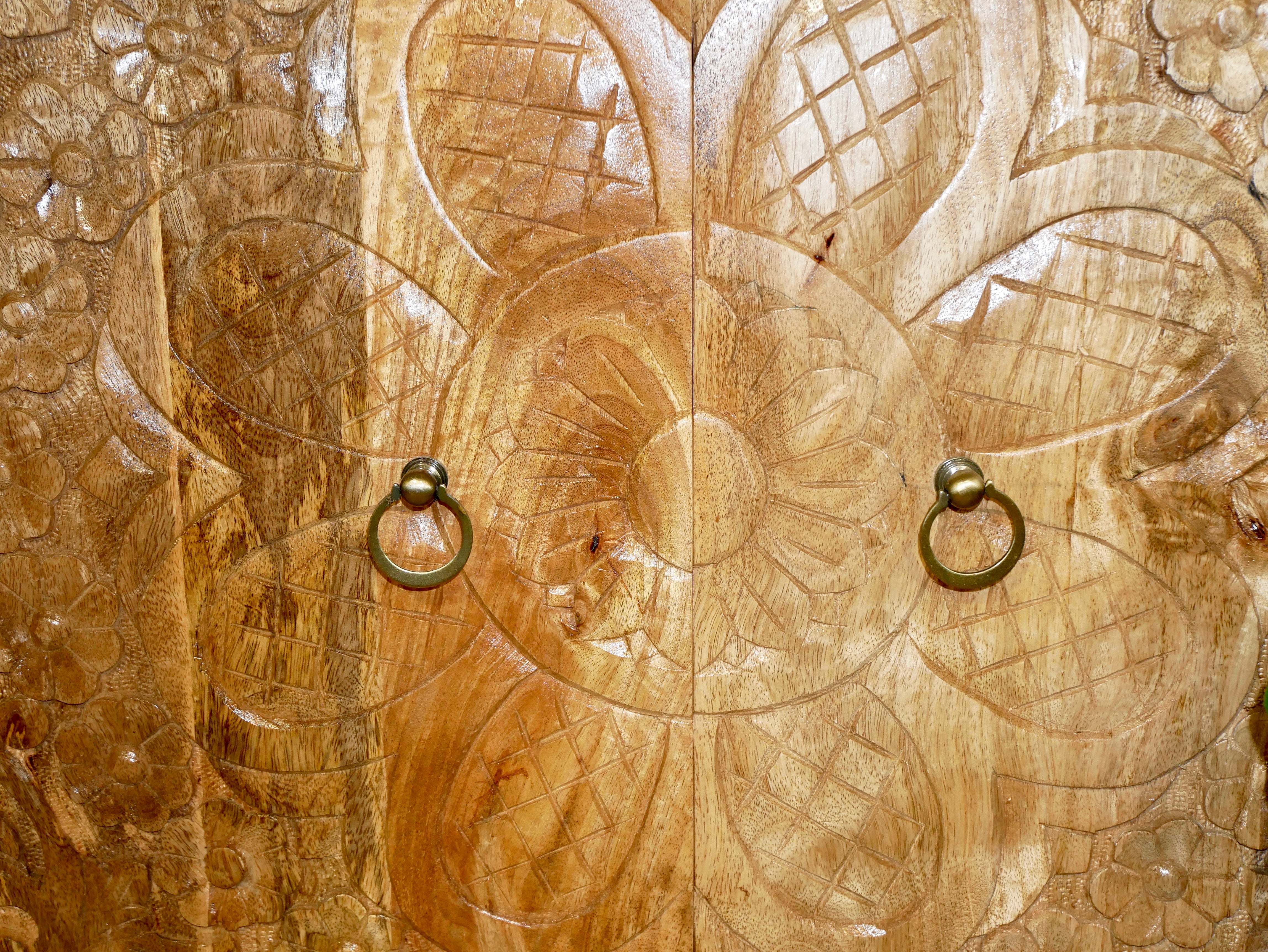 Close up image of a boho style mango wood furniture cabinet with hand-carved floral doors, Mediterranean-inspired design, 90 × 90 × 40 cm.