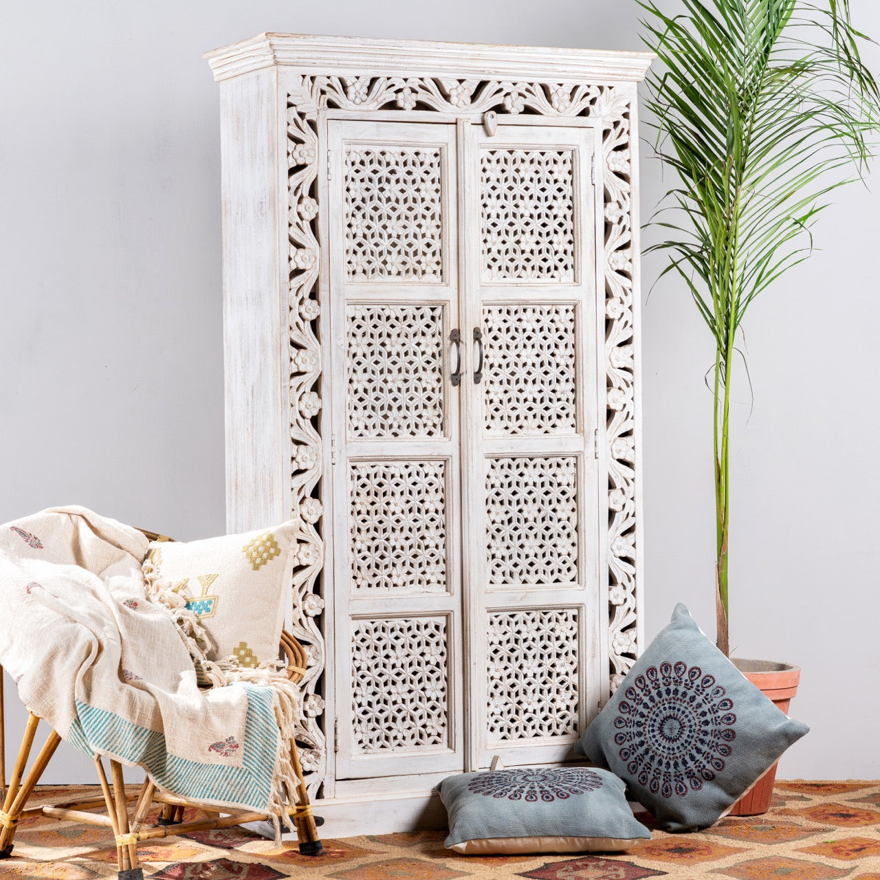 Side angle image of a hand-carved mango wood cabinet with floral and geometric patterns in white-wash finish – carved wooden furniture and artisanal furniture with Mediterranean charm.